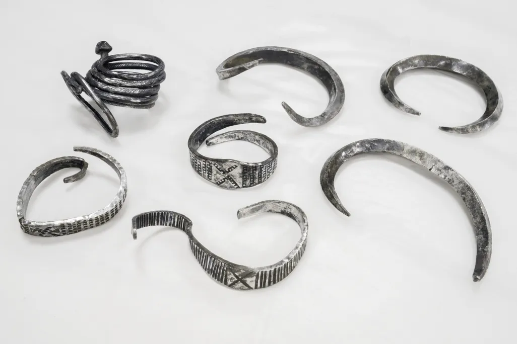 Seven silver bands on a white surface