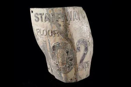 This damaged floor marker, labeled “Stairwell C, Floor 102,” was recovered from the debris of the World Trade Center and is now housed in the National Museum of American History's National September 11 Collection.