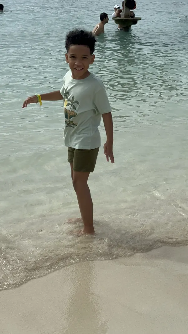 My son soaking his feet at the beach on cruise vacation in Haiti thumbnail