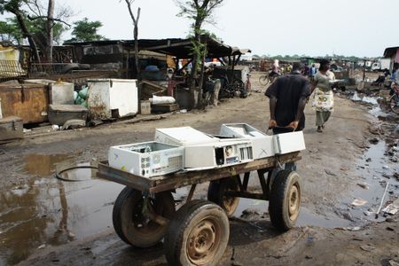 A man pulls a cart full of empty PC cases that'll be broken down by recyclers in Agbogbloshie, in Accra, Ghana.