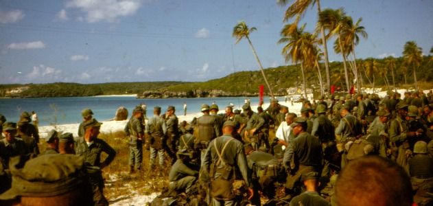 “Sweaty troops on the beach prepare to move out.”