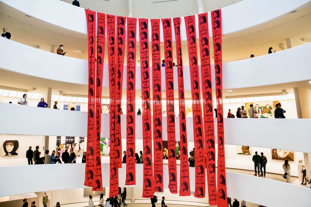 Red banners with Mahsa Amini’s face cover the Guggenheim spiral in anonymous protest action