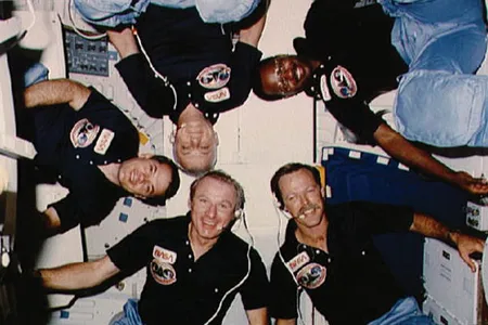 Dubbed the "human satellite," McCandless (bottom center, with the 1984 Challenger crew, including pilot-photographer Gibson, upper left) now works on space robots.