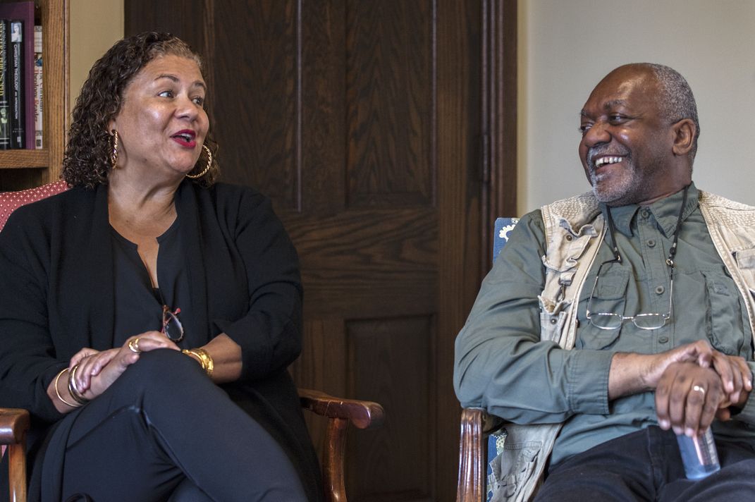 Elizabeth Alexander, a Black woman, seated left, in conversation and smiling with Kerry James Marshall, a Black man