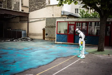 A worker sprays a gel on the ground to absorb lead as he takes part in a clean-up operation at Saint Benoit school near Notre-Dame cathedral in Paris during a decontamination operation on August 8, 2019. 