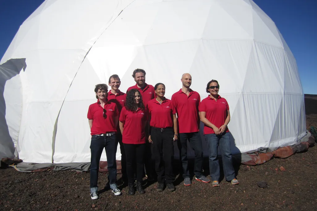 people in red polos outside a HI-SEAS habitat