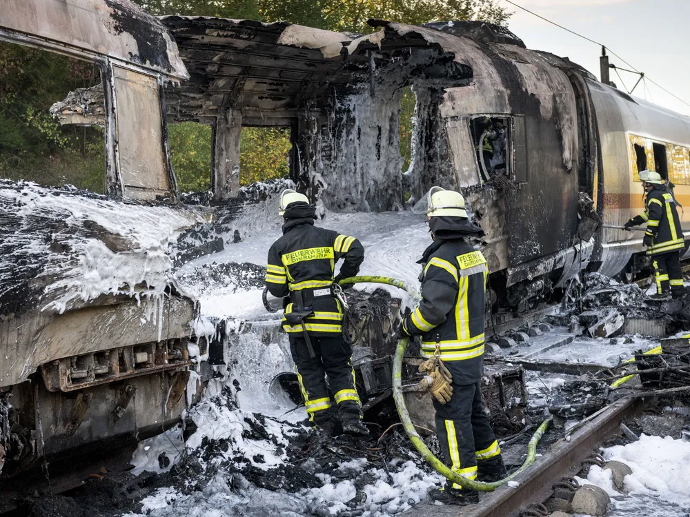 Firefighters use foam to extinguish a fire on a train car