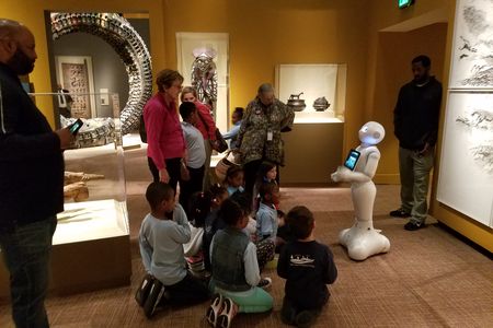 Pepper talks to a group of museum visitors on the lower level of the National Museum of African Art. 