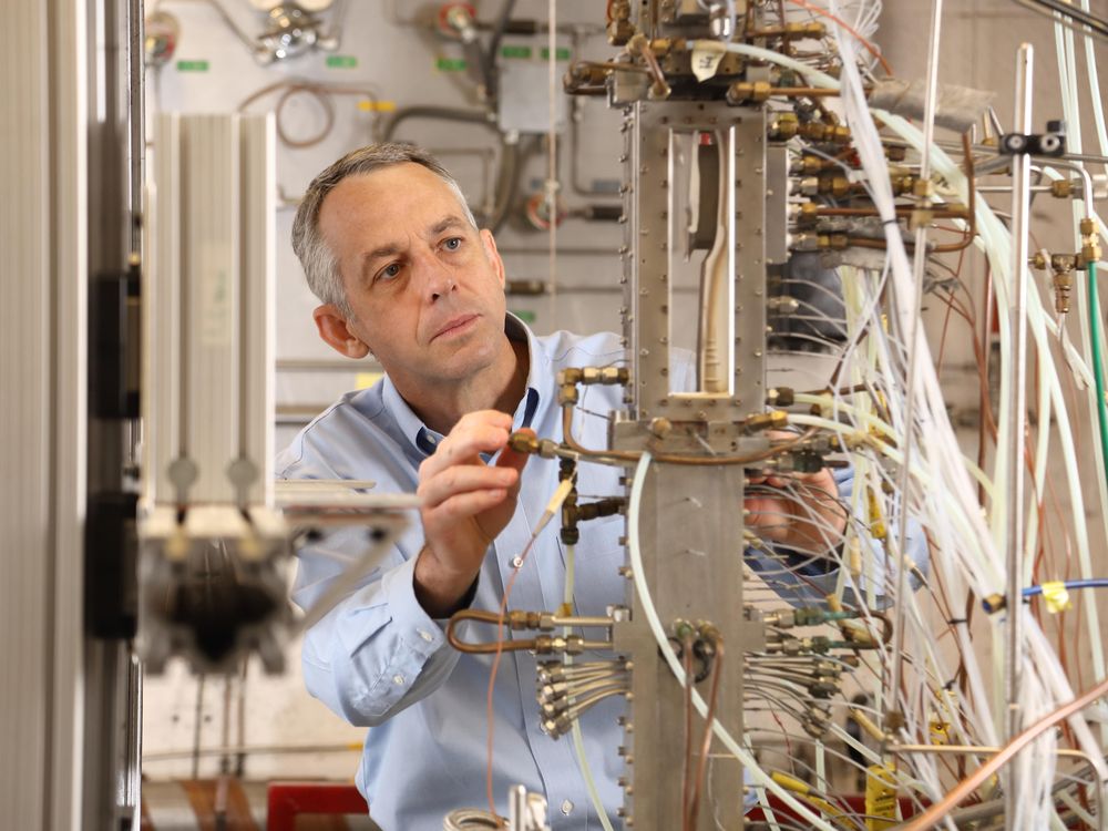 Chris Goyne looking at array of tubes and wires