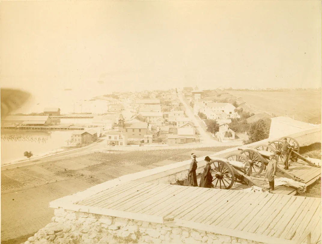 Visitors stand next to cannons at Fort Mackinac.