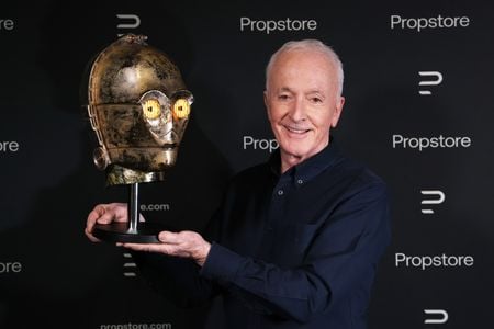 Actor Anthony Daniels holds up the helmet he wore on the set of 1983&#39;s Return of the Jedi.