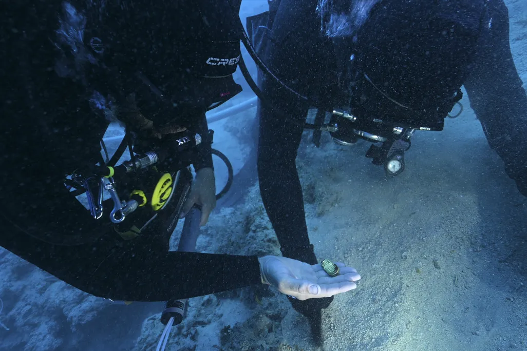 Divers examine a gold object recovered from the Byzantine wreck