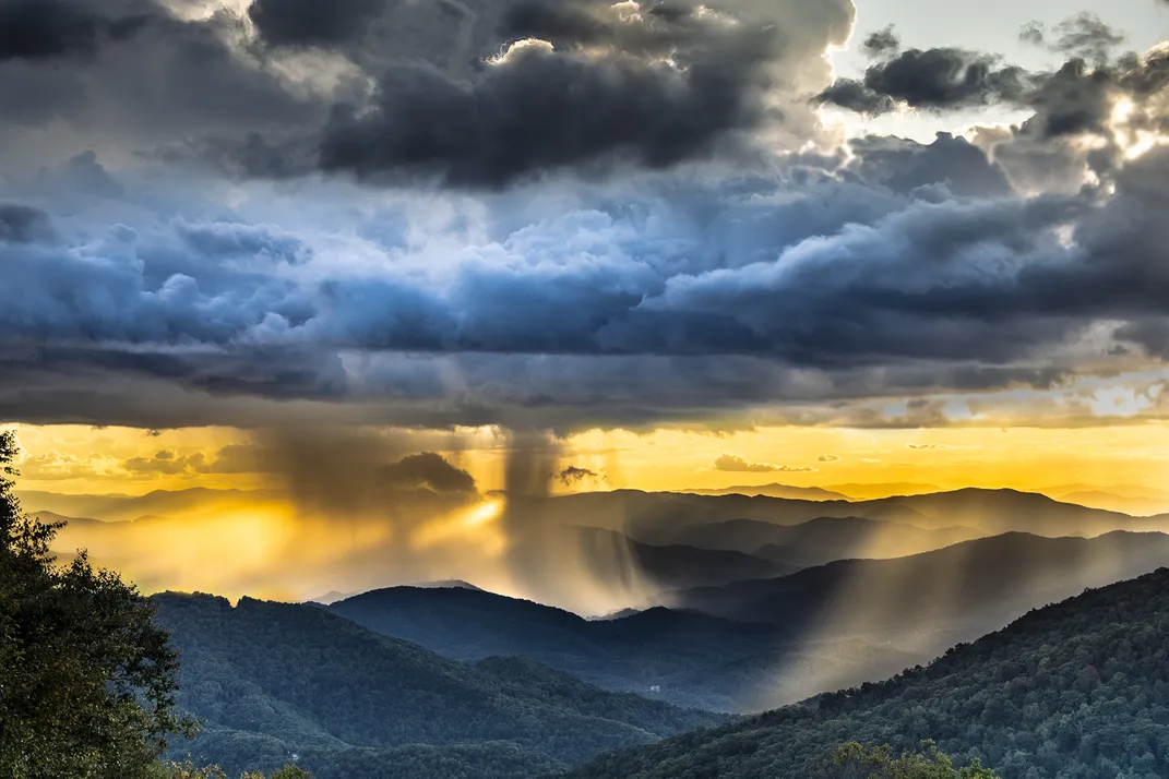 15 - Rain clouds hover over tree-covered peaks of the Blue Ridge Mountains as the sun breaks through.