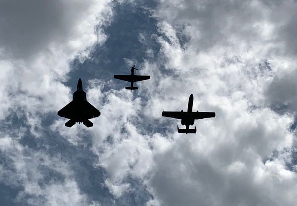 Heritage Flight silhouetted against a partly cloudy sky. thumbnail