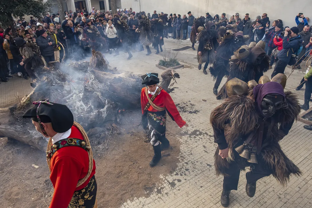 Led by the Issohadores, the Mamuthones circle a bonfire blessed by the priest of Mamoiada’s Mother Church. Representatives of each neighborhood will use embers from this blaze to start dozens of local bonfires, which the characters will then visit and cir