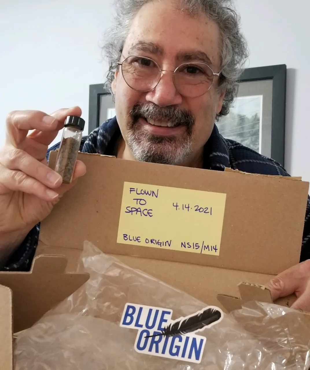 man removes vial of dinosaur bones from box marked "flown to space"