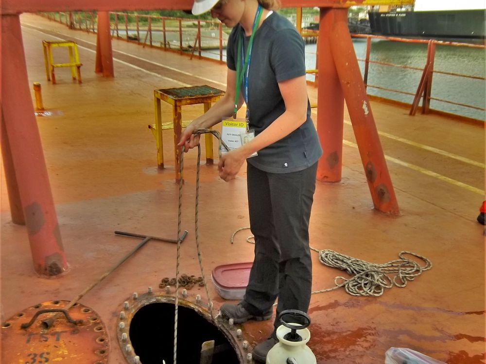 The author lowers a net into a topside ballast water tank to sample marine plankton and zooplankton