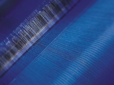 A close-up of fabric in a loom