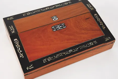 The exterior is made of fruitwood&nbsp;adorned with mother-of-pearl inlay and silver banding.