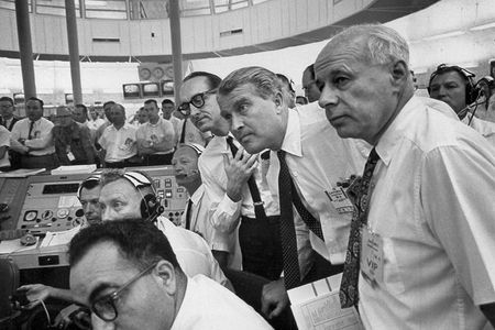 Wernher von Braun (center, standing), George Mueller (to his right) and other members of the NASA team watch an Apollo test flight in 1964.