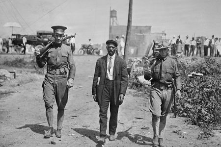 Two National Guard escort an African-American man in the tense summer weeks of 1917 in East St. Louis, Illinois.