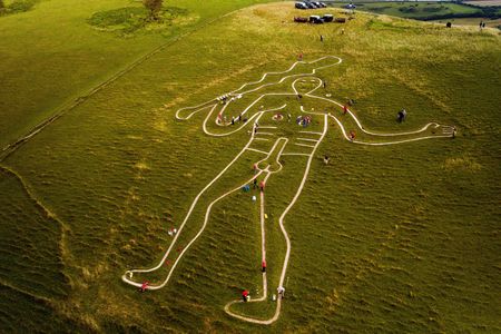 Volunteers repair and re-chalk the Cerne Abbas Giant in Dorset, England. The 180-foot figure has been on the grassy hillside as long as anyone alive can remember, but many wondered if it might be thousands of years old. Now, new evidence suggests the drawing dates not to the prehistoric period, but to medieval times.