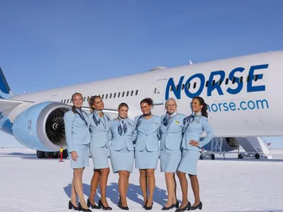 Flight attendants pose in front of the Boeing 787 Dreamliner on Troll Airfield in Queen Maud Land, Antarctica.