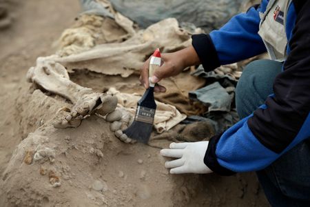 An archeologist works at the site where 16 tombs belonging to 19th-century Chinese immigrants were discovered, at Huaca Bellavista in Lima, Peru.