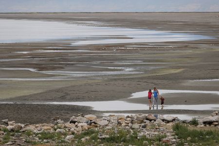 Park visitors walk along a section of the Great Salt Lake that used to be underwater at the Great Salt Lake State Park near Magna, Utah.&nbsp;