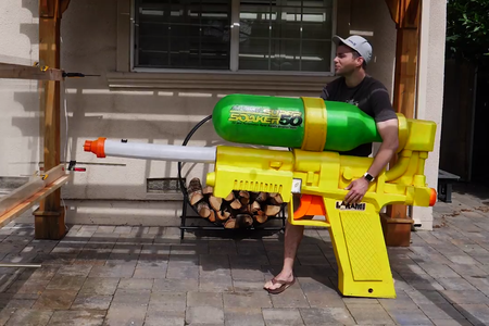 Engineer Mark Rober posing with his Super Soaker creation