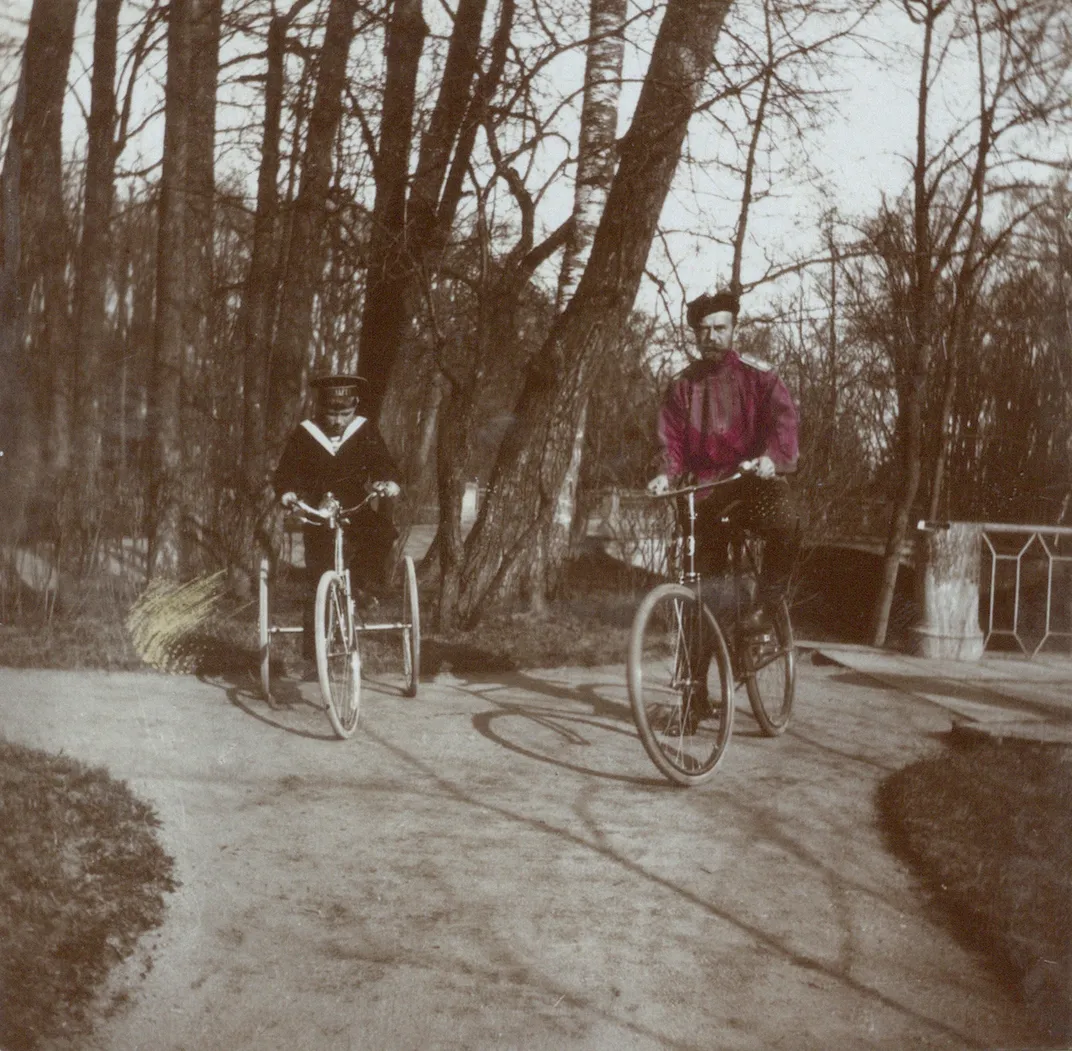 A hand-colorized photo of Alexei and Nicholas riding bikes in 1913