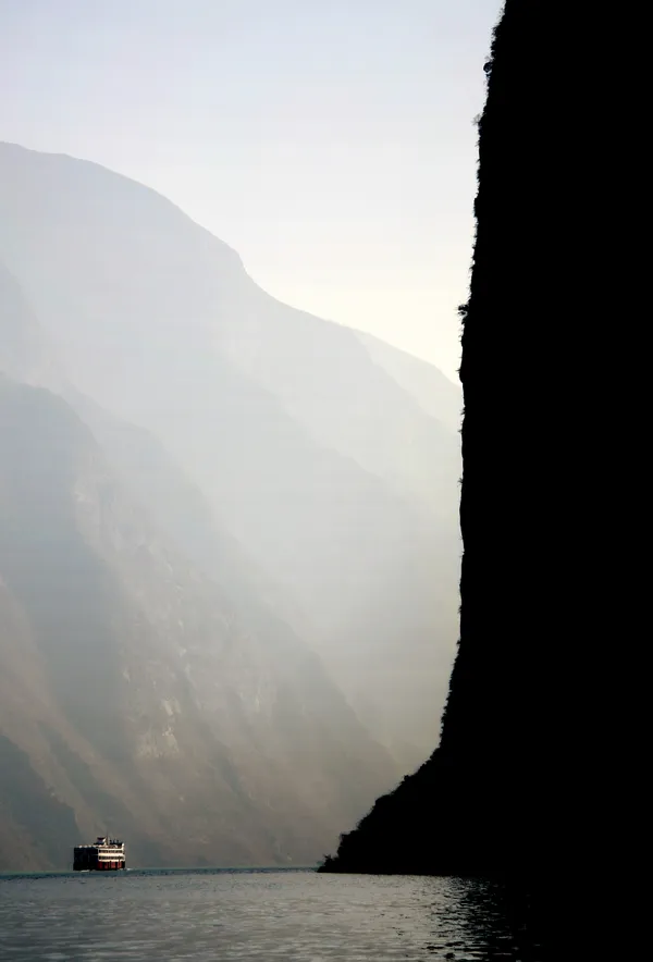 A mountain dwarfs a passenger boat in the Three Gorges area of the Yangzi River. thumbnail