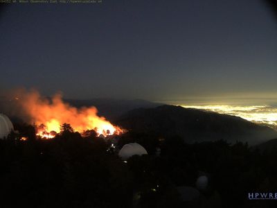 A webcam view of Mount Wilson Observatory's trademark white domes, with fires raging in the background on September 19.