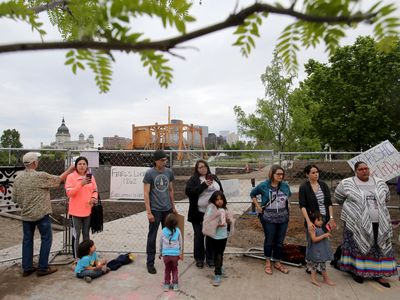 Protestors stand in front of the Walker Sculpture Garden's construction fence on Saturday, May 27, 2017.