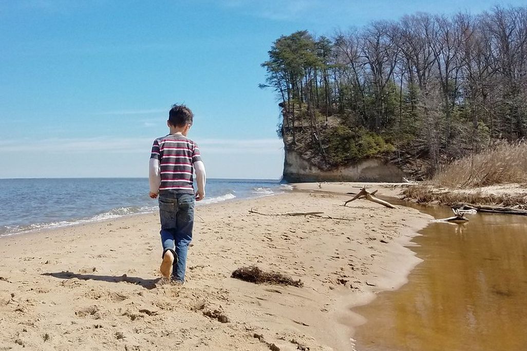 Boy walking on beach at Westmoreland State Park.jpg
