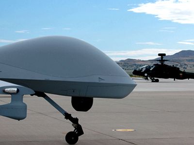 A Gray Eagle unmanned vehicle (left) and Apache helicopter share the spotlight during the recent MUSIC demonstration in Utah.