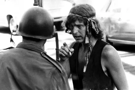 A man smokes a cigarette as he talks to an armored guard at a protest in People’s Park circa May, 1969, in Berkeley, California.