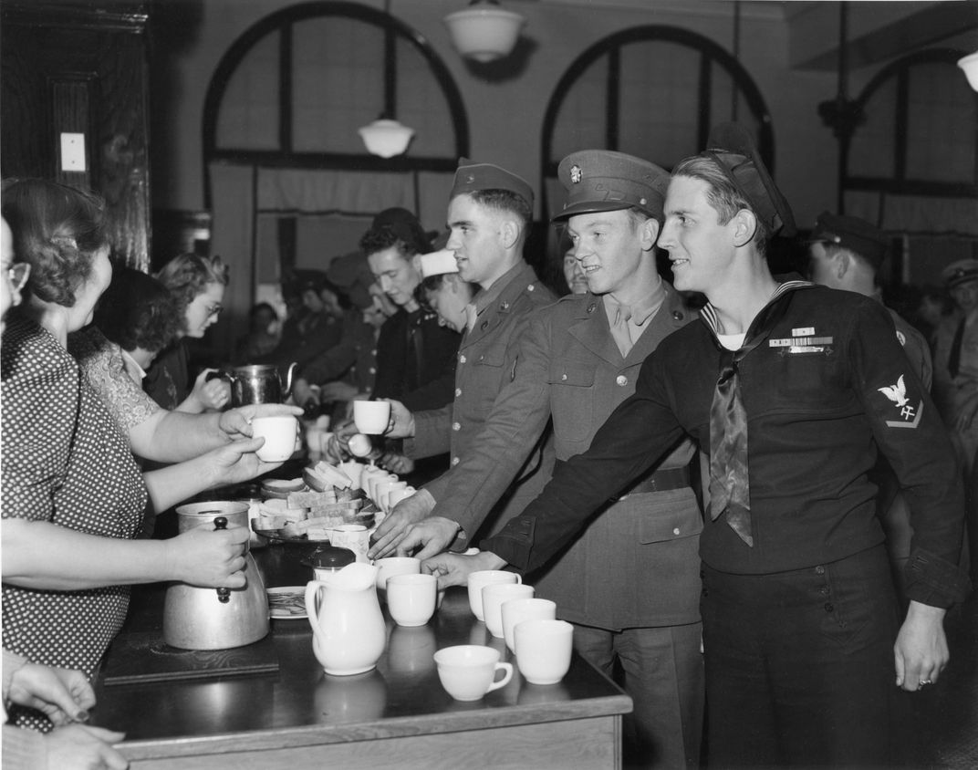 Soldiers and sailors pick up food and drinks at the canteen.