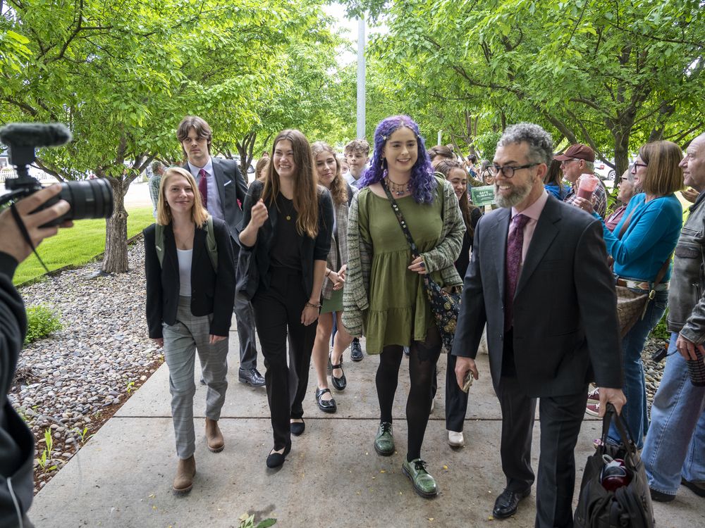 Group of people walking down a sidewalk