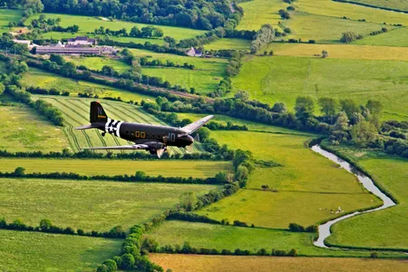 Over the now-peaceful farms of Sainte-Marie-du-Mont, which 75 years ago was within Drop Zone C for D-Day paratroopers, a C-47 returns to base after delivering its paratroop reenactors. They were there for the 2014 commemoration of one of the most momentous days of World War II.