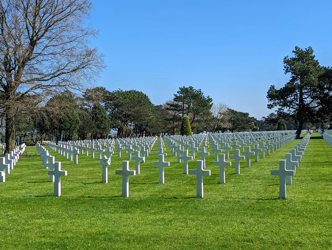 White crosses in cemetery on green grass