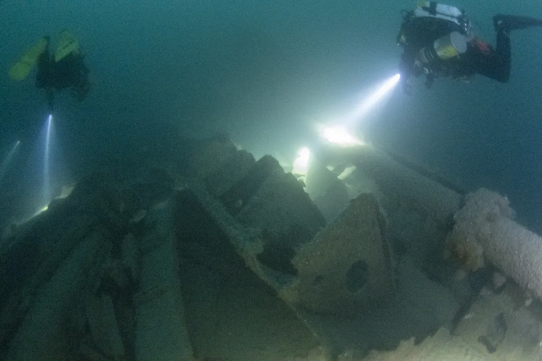 Two divers with lights under water