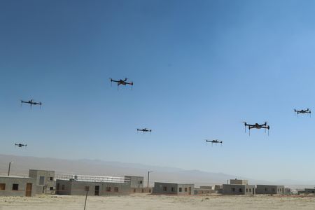 This is only a drill, for now: Over the fictional town of Razish at the National Training Center at Fort Irwin, California, 40 quadcopters fly in a swarm.