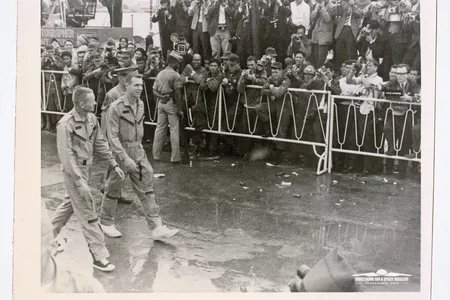 Astronauts Neil Armstrong (left) and David Scott (right) greet well-wishers at Naha Air Base in Okinawa, Japan, shortly after the Gemini 8 spacecraft spun out of control.