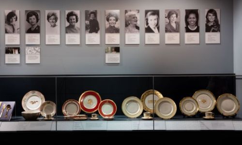 exhibition features White House China in different colors and patterns below photographs of contemporary first ladies