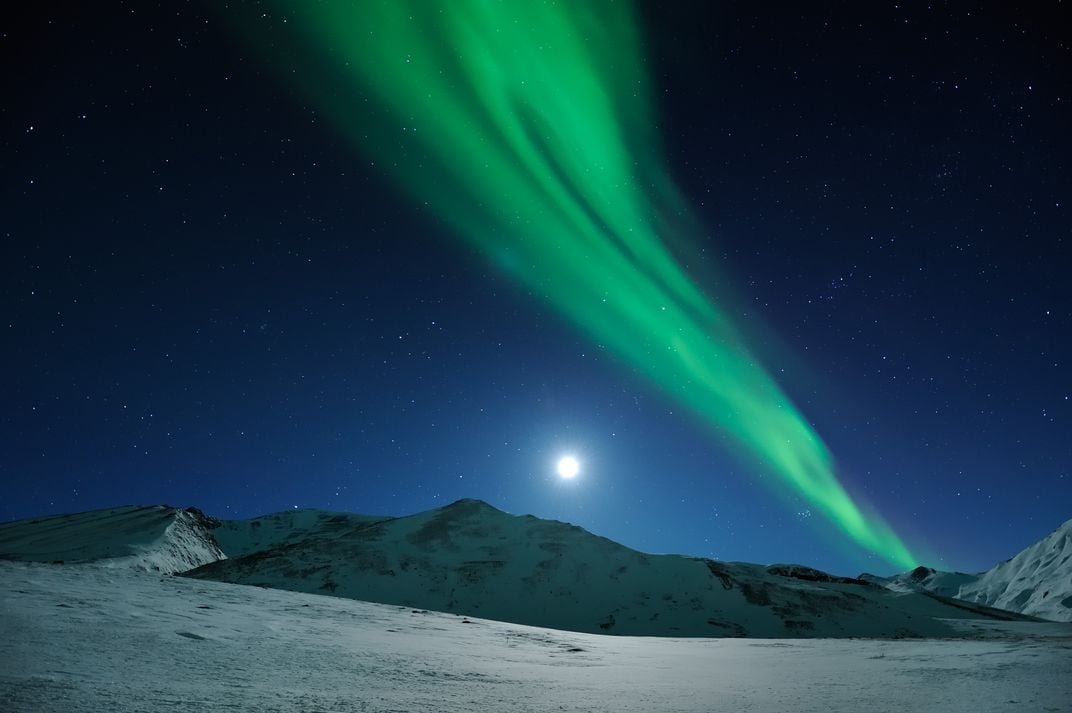Moonrise Over Northern Lights -- a brilliant aurora shines above a nearly  full moon during a chilly winter night on Alaska's north slope, Smithsonian Photo Contest