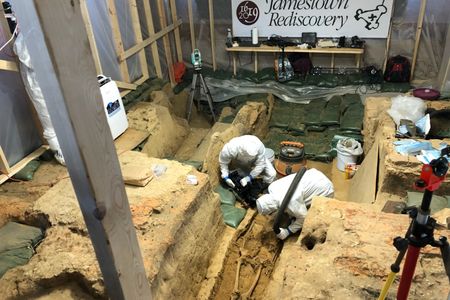 Scientists don full-body suits to minimize contamination and disturbance of the precious artifacts uncovered in the 1617 church in Jamestown, Virginia, where a new skeleton awaits identification.