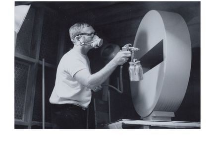 Photograph of Tony DeLap spray painting sculpture in Costa Mesa studio (detail), 1970 March / unidentified photographer. Tony DeLap papers, circa 1950-2015. Archives of American Art, Smithsonian Institution.