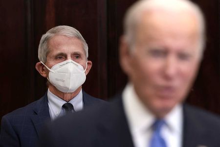 Anthony Fauci (left), director of the National Institute of Allergy and Infectious Diseases and chief medical advisor to the President, listens as President Joe Biden (right) delivers remarks on the Omicron Covid-19 variant. Fauci has warned that Omicron could reach most of the population.