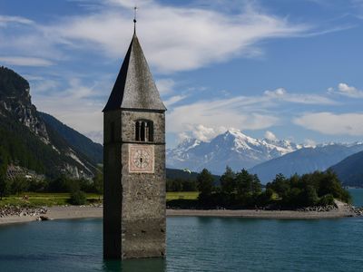 This July 9, 2020, photograph shows a 14th-century bell tower peeking out of Lake Resia in northern Italy. The building—and the historic town it once stood in—were submerged in an artificial lake in 1950 to generate power for a nearby hydroelectric plant.